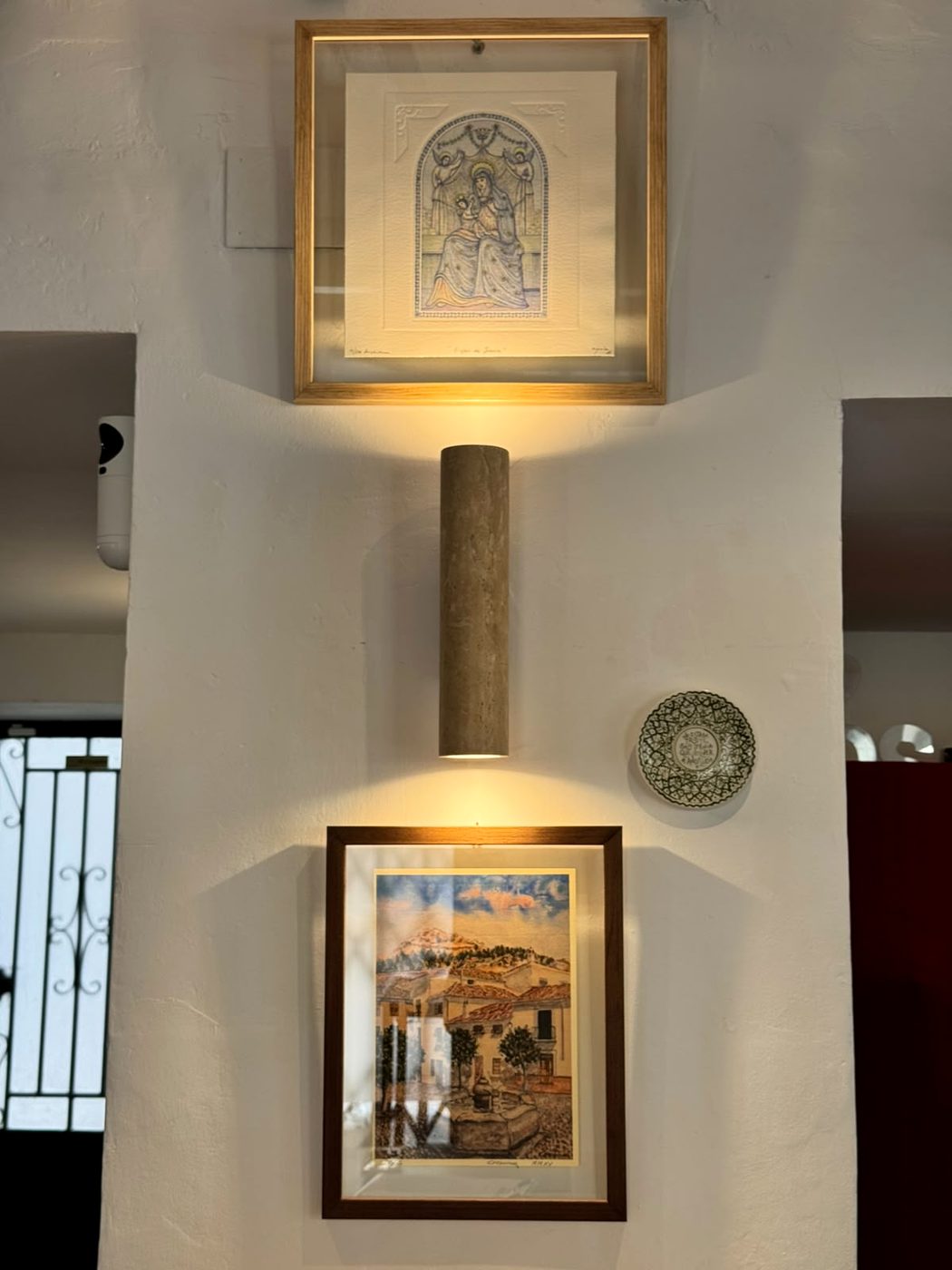 Cuadros iluminados en la pared encalada