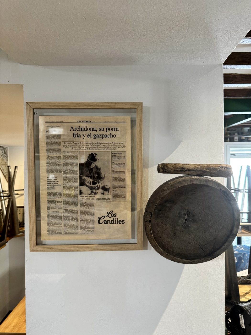 Recorte de periódico enmarcado sobre la porra de Archidona, junto a un dornillo de madera