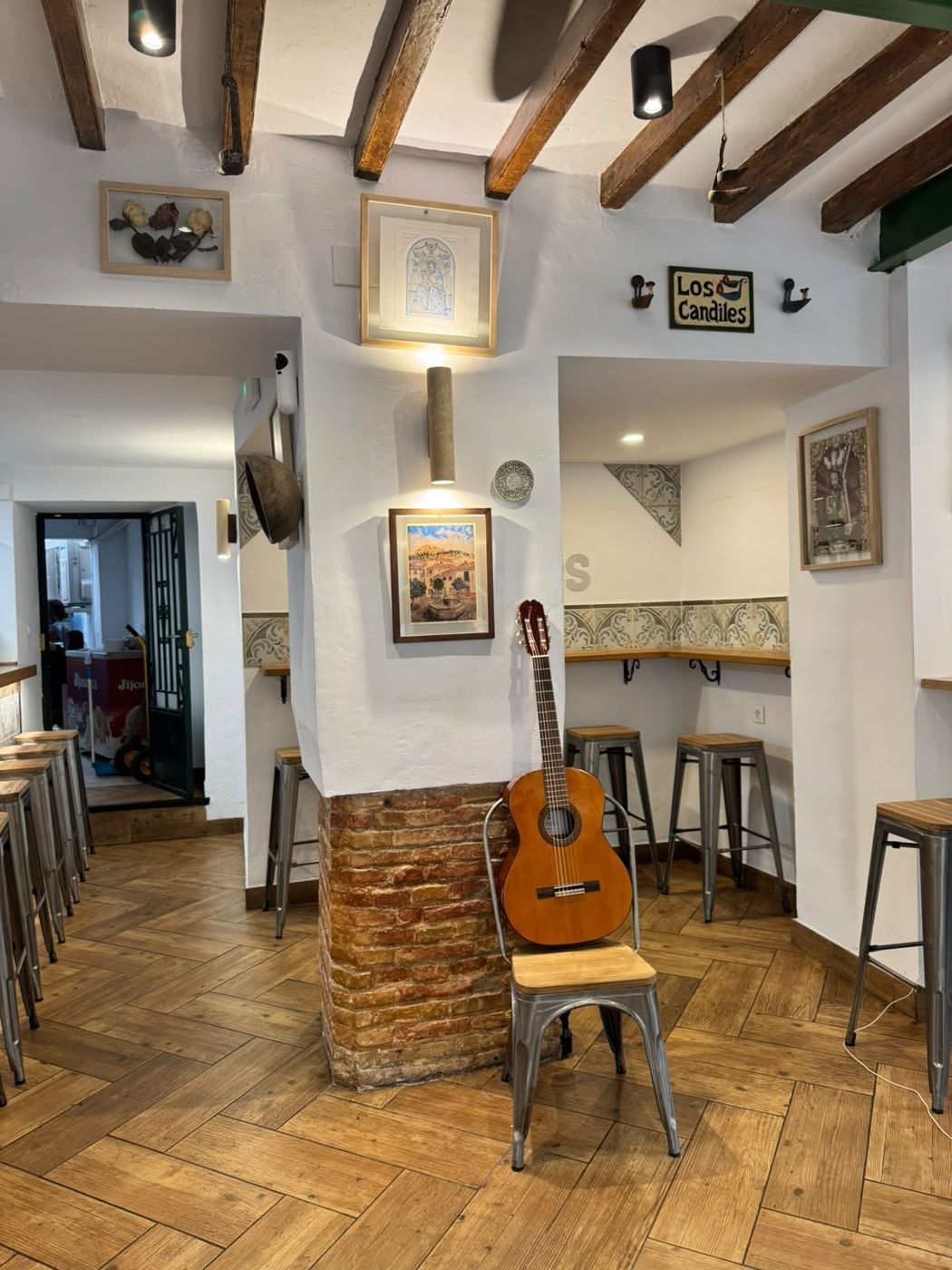 Interior de Los Candiles con una guitarra apoyada junto a la barra